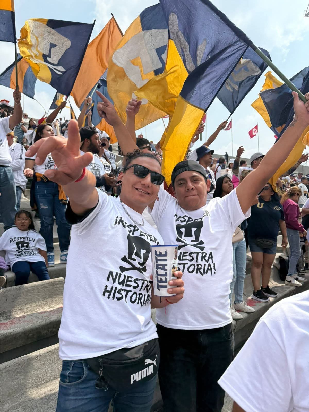 Aficionados de Pumas con banderas en el estadio